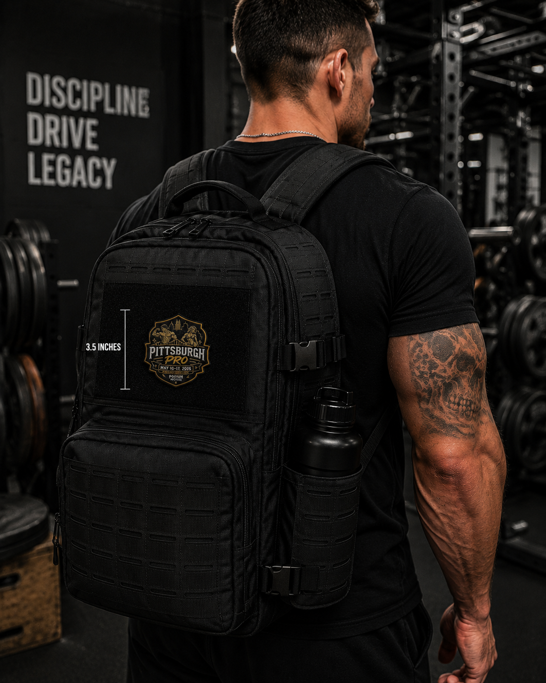 A man in a black t-shirt seen from behind wearing a black tactical backpack with a side water bottle, set in a dark gym environment. A graphic overlay on the backpack shows its 3.