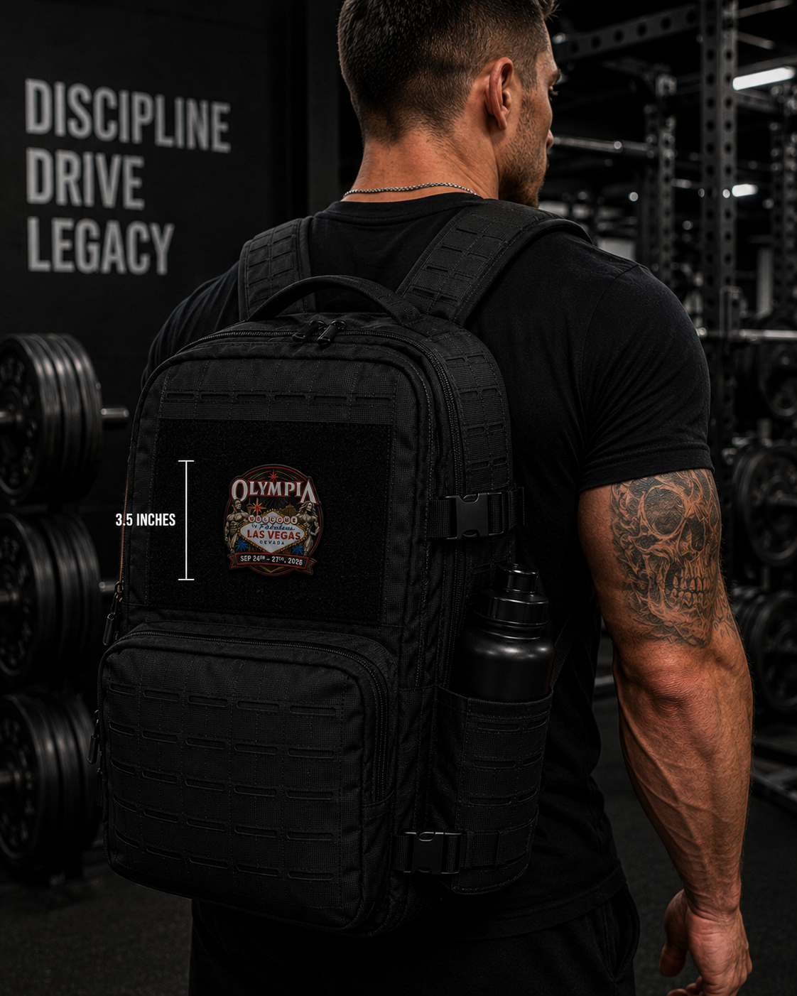 A man in a black t-shirt wearing a black tactical backpack with a custom 'Olympia' patch on the front pocket, set in a gym environment. A white text overlay indicates the backpack's height is 3.